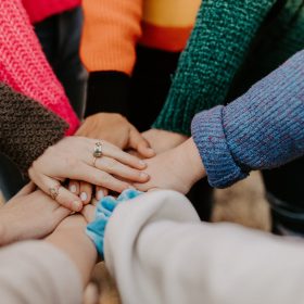 Le mani di persone diverse si stringono fra loro